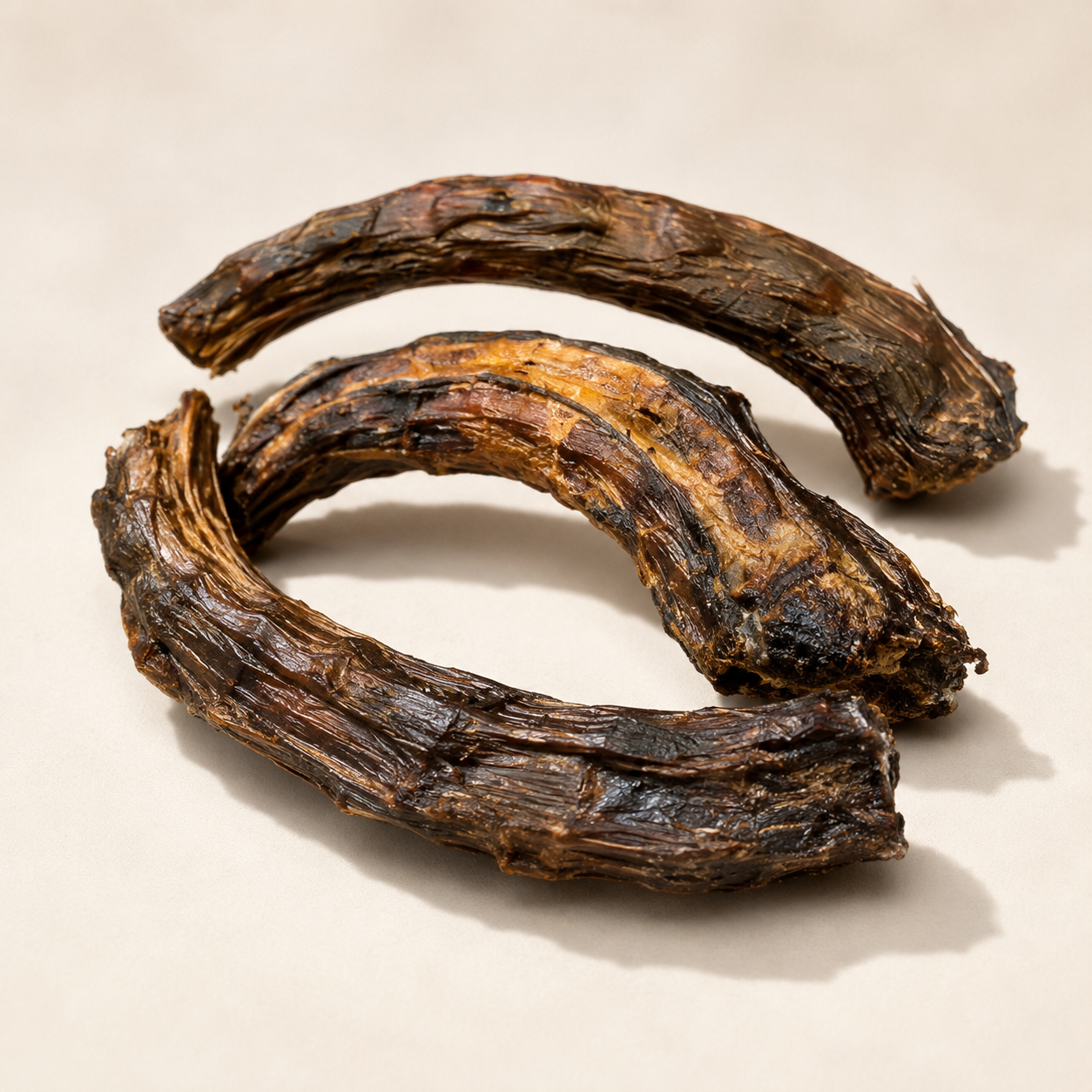 Close up of air dehydrated Australian emu neck chews showing natural fibrous texture and curved chew shape