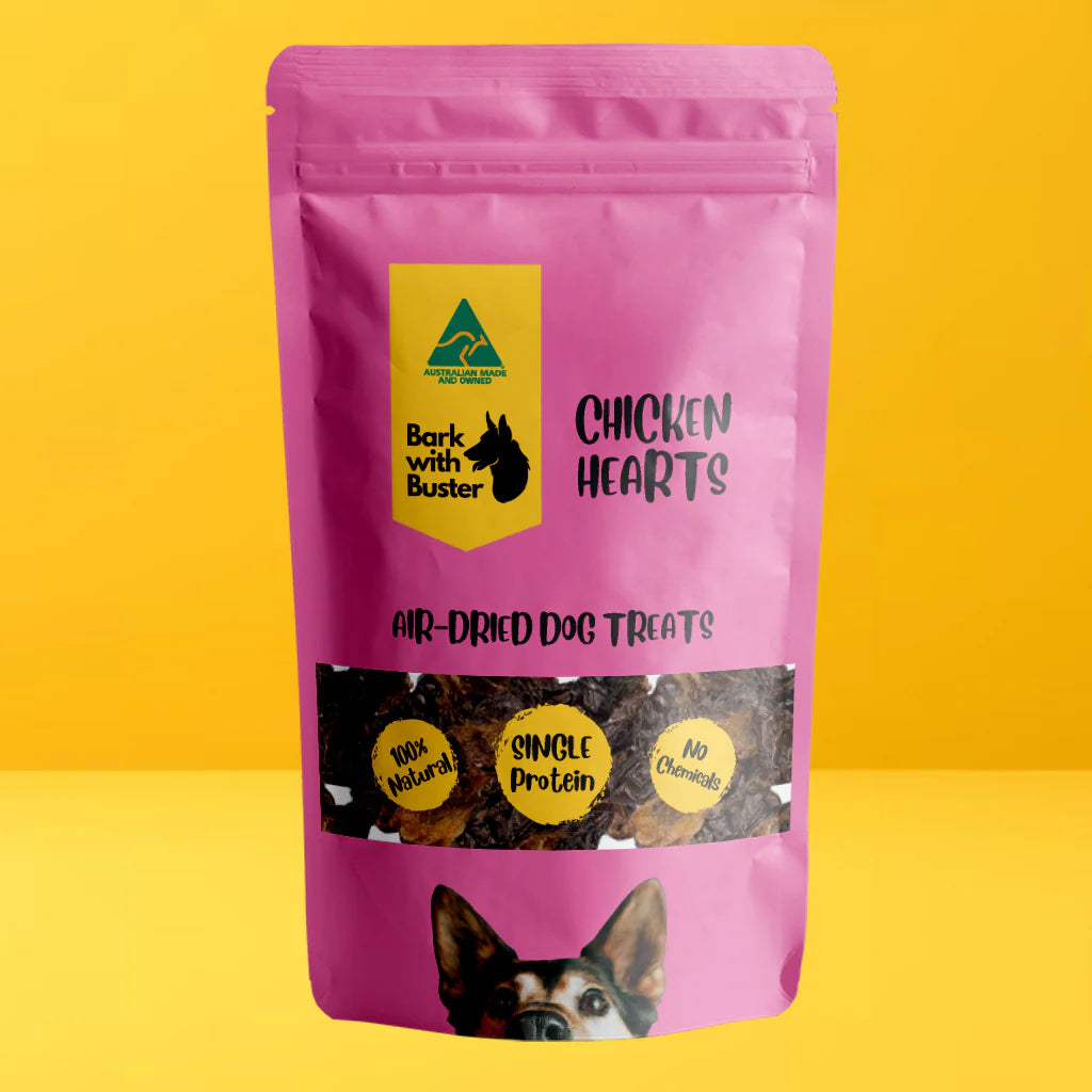 Pink package of 'Bark with Buster Chicken Hearts' dog treats on a yellow background