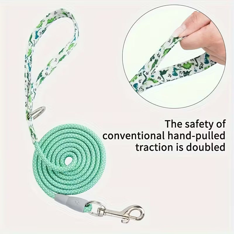 Dog leash with floral pattern and coiled green rope, held by a hand, on a light pink background.