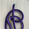 Black and purple braided rope leash with a metal clip on a wooden surface