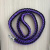 Black and purple braided leash on a wooden surface