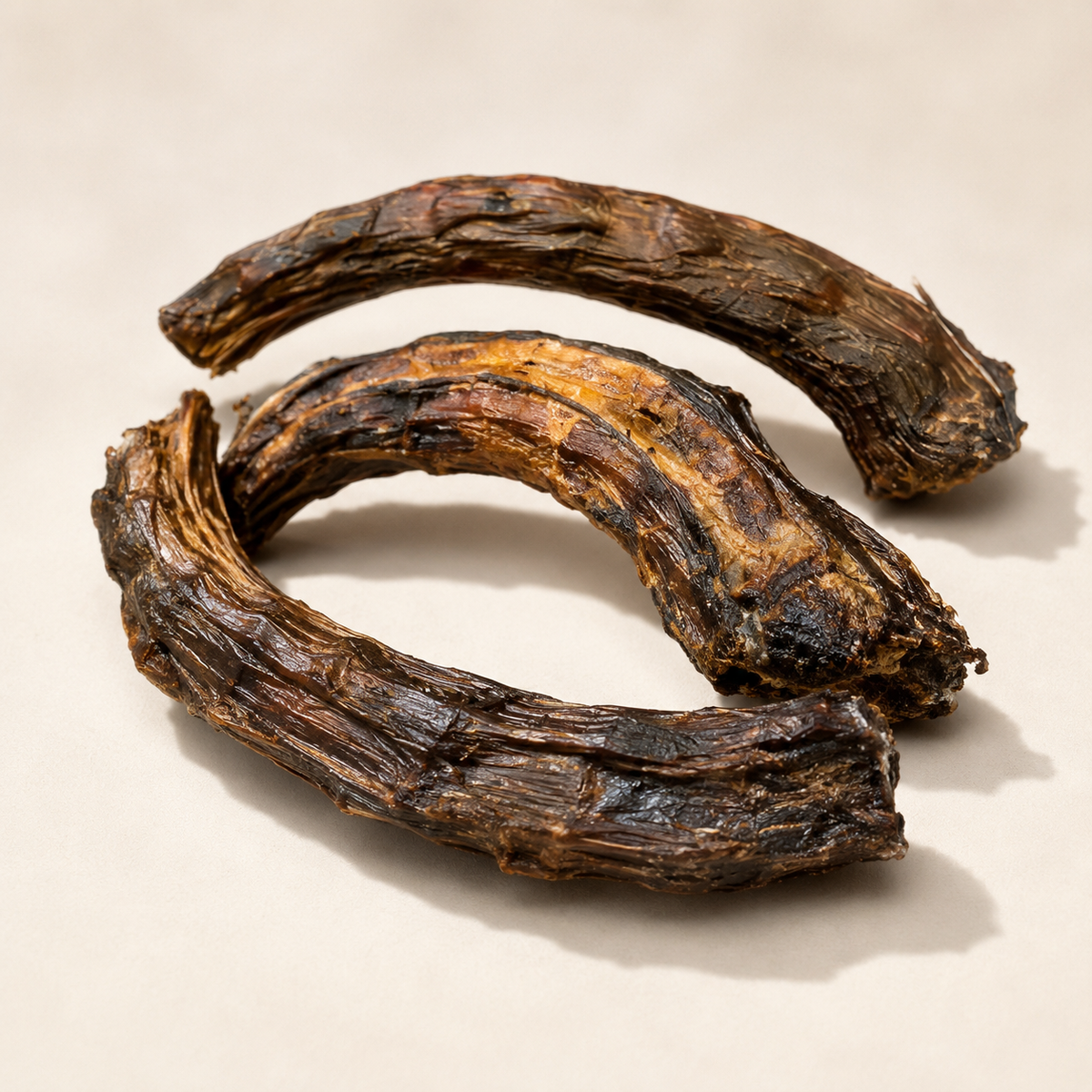 Close up of air dehydrated Australian emu neck chews showing natural fibrous texture and curved chew shape 